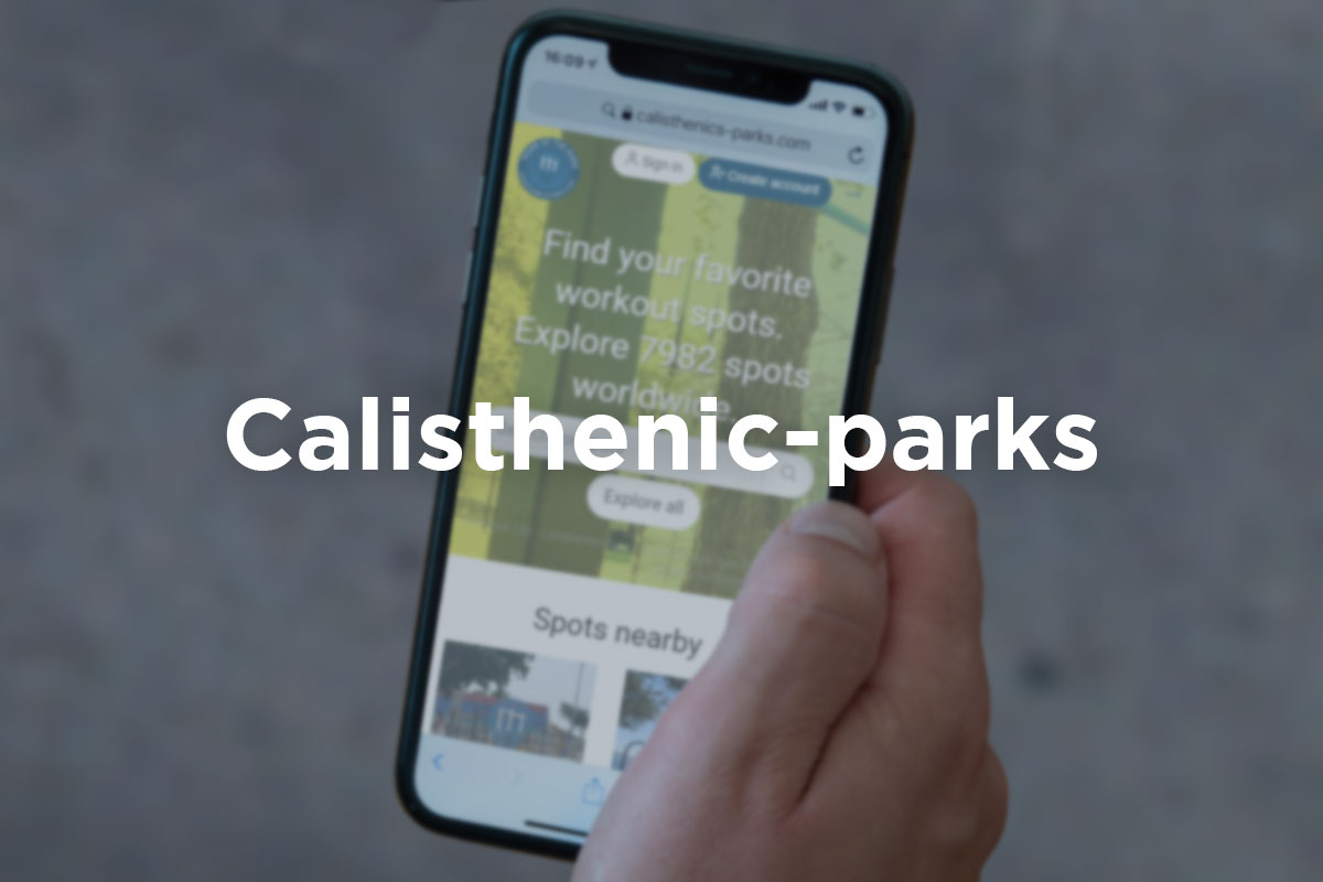 Slightly blurred picture of male hand holding a cellphone with app Calisthenics-Park opened in it. ‘’Calisthenic-Park’’ written in a white letter over the picture.