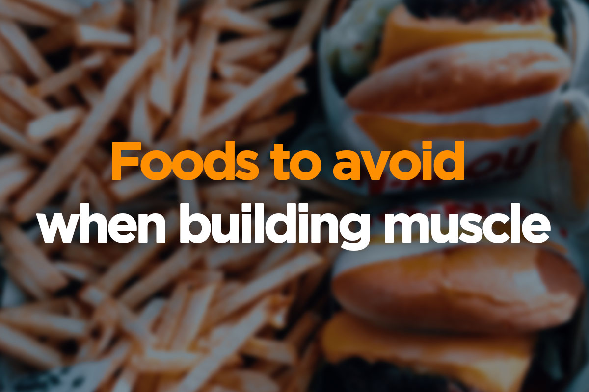 The text is written over the picture in two lines. First, upper line, says ''Foods to avoid'' and is written in orange font. Second, lower line, is written in a white font and is saying: ''when building muscle''. The writing is placed on a blurred picture of french fries and two burgers.